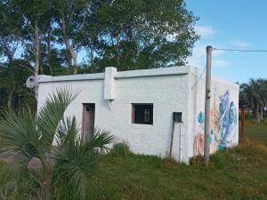 Casa rural cerca del Cabo في Rincón de los Oliveras: مبنى ابيض وعليه لوحه جانبيه