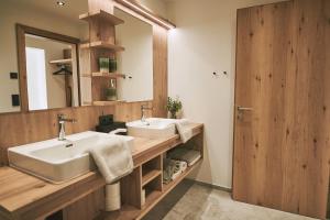 ein Badezimmer mit zwei Waschbecken und einem großen Spiegel in der Unterkunft Brandnerhof in Brand