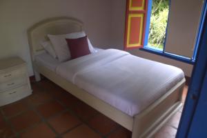 um quarto com uma cama com lençóis brancos e uma janela em CASA DE CAMPO VILLA OLI!! - Un paraiso natural en la ciudad em Villamaría