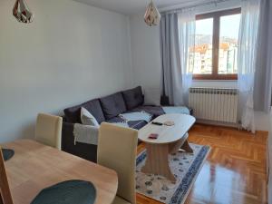 a living room with a couch and a table at Apartman Dobrinja in Sarajevo