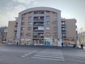 a large building with people walking in front of it at Apartman Dobrinja in Sarajevo