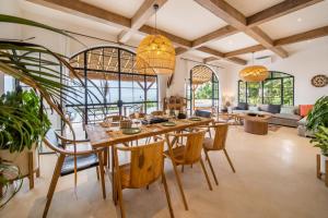 une salle à manger avec une grande table et des chaises en bois dans l'établissement Villa Moonlight Lovina, à Buleleng