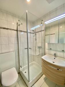 ein Bad mit einer Dusche, einem WC und einem Waschbecken in der Unterkunft ADORIS APPARTEMENTS im Lotzbeckpark am See "nachhaltiges Wohnen in Lindau" in Lindau