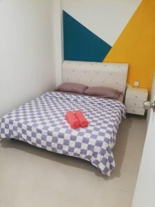 - un lit avec 2 oreillers rouges dans l'établissement Wincy Home Metrocity Kuching-N, à Kuching