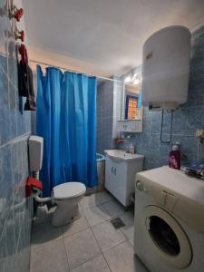 a bathroom with a toilet and a blue shower curtain at Kamenovo sea in Budva
