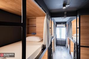 1 dormitorio con 2 literas y paredes de madera en Bunkbed Hostel, en Makkasan