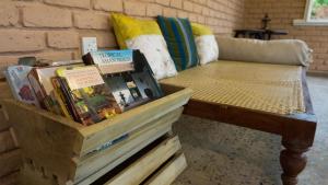 ein Zimmer mit einem Sofa und einem Tisch mit Büchern in der Unterkunft Araliya Villa by Ella Nine Peaks in Ella