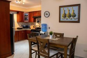una cocina con mesa y sillas y un reloj en la pared en Casa Linda beautiful Villa, en Sosúa