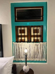 a lamp on a table in front of a window at Ella Nine Peaks in Ella