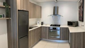 uma cozinha com um frigorífico de aço inoxidável e um fogão em Villa 17 - Spacious Apartment in Green Point na Cidade do Cabo