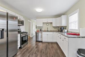 a kitchen with white cabinets and stainless steel appliances at Cottage By David Rigney Real Estate Solutions in Lake Geneva