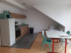 a kitchen with a white refrigerator and a table with chairs at AVI City Burgplatz Apartments in Düsseldorf