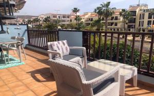 a balcony with two chairs and a table with a view of the water at El Mirador Los Cristianos in Los Cristianos