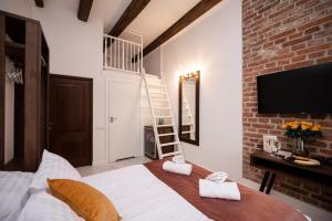 1 dormitorio con 1 cama y TV en la pared en Hive Family House en Cracovia