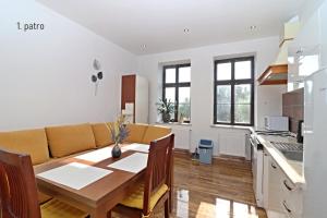 cocina y sala de estar con mesa de madera y comedor en Apartmány U Floriánů en Žacléř