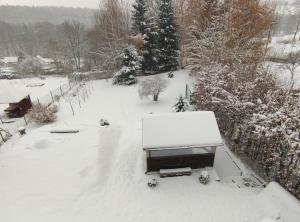 un patio cubierto de nieve con un camión cubierto de nieve en Apartmány U Floriánů en Žacléř