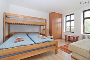 a bedroom with a bunk bed and a couch at Apartmány U Floriánů in Žacléř
