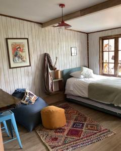 a bedroom with a bed and a table and a rug at Departamento La Solar 1 ambiente in Frutillar