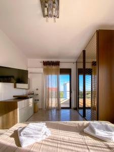 1 dormitorio con 1 cama y cocina con puertas correderas de cristal en Rosalia House, en Rodas