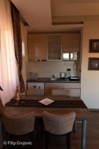 una cucina con tavolo, sedie e piano di lavoro di Apartment G6 a Kopaonik