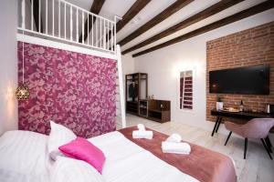 1 dormitorio con 1 cama grande y pared de color rosa en Hive Family House, en Cracovia