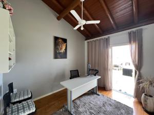 a white desk in a room with a ceiling fan at Residencial Manauara Torres in Torres