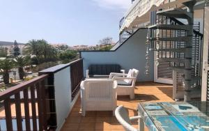 a balcony with chairs and a table and a staircase at El Mirador Los Cristianos in Los Cristianos