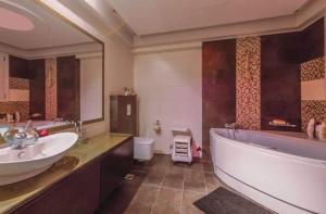 a bathroom with a tub and a sink and a toilet at Villa Fotaki in Kos Town +14 photos