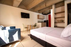 1 dormitorio con 1 cama y cocina con mesa en MANGATA LIVING, en Medellín
