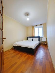 a bedroom with a bed and a wooden floor at Слава Героям 11 Сеть апартаментов Alex Apartments Бесконтактное заселение 24-7 in Poltava