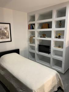 een witte slaapkamer met een bed en een televisie bij Douro Box in Castelo de Paiva +11 foto's