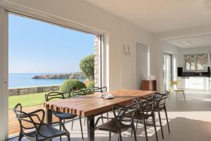 a dining room with a table and chairs and a large window at Villa Thalassa in Ferma