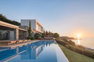 een zwembad voor een huis met uitzicht op de oceaan bij Villa Thalassa in Ferma