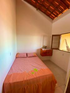 a bedroom with a bed in a room with a window at Chalé da Kikia in Icapuí