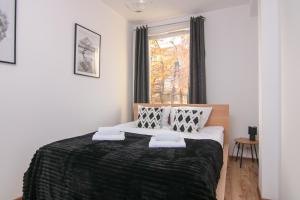 1 dormitorio con 1 cama grande y ventana en DMK Green Apartment near Warsaw-Modlin Airport en Nowy Dwór Mazowiecki