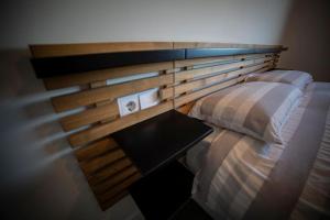 1 dormitorio con cabecero de madera y 1 cama con mesa en Precioso atico con vistas al mar 20 metros de Playa de Usil, en Miengo