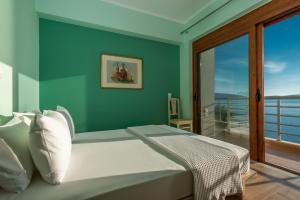 a bedroom with a bed with a view of the ocean at Iris Villas Lefkada - Marine Villa in Évyiros