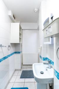 a white bathroom with a sink and a shower at "Furnished Rentals Direct" DominionHouse cul-de-sac Home for 6 people in Anfield near LFC, Goodison Park, Free Street Parking, Suits Travellers, contractors and Family, Near Football action and 10 minutes drive to Liverpool City Centre in Liverpool
