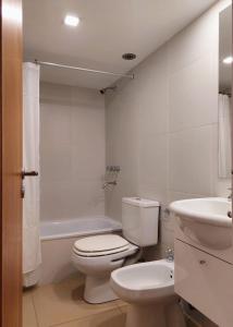 ein weißes Badezimmer mit Toilette und Waschbecken in der Unterkunft Amanecer en el Lago in San Carlos de Bariloche + 12 Fotos
