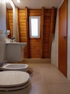 ein Badezimmer mit Toilette und Waschbecken und einem Fenster in der Unterkunft Amanecer en el Lago in San Carlos de Bariloche
