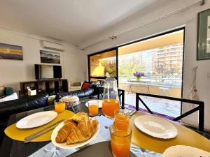 a table with bread and orange juice on top of it at Vilamoura Marina Mar 1 with Pool by Homing in Vilamoura