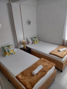Dos camas en una habitación con toallas. en QUINDIOAPARTAMENTOTURISTICO, en Armenia