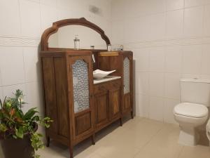 a bathroom with a wooden sink and a toilet at KIKO in Tramandaí