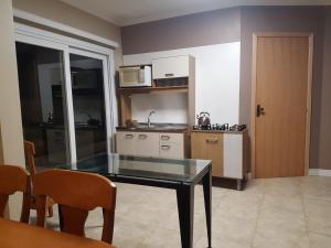 a kitchen with a glass table in a room at KIKO in Tramandaí