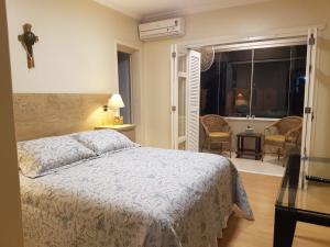 sypialnia z łóżkiem, oknem i krzesłami w obiekcie KIKO w mieście Tramandaí