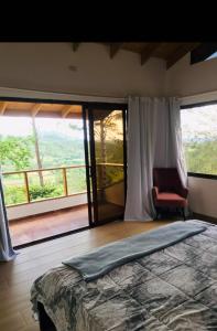sypialnia z dużym łóżkiem i balkonem w obiekcie Lote 13N (Quintas del Bosque) Los Helechos w mieście Los Corozos