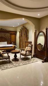 1 dormitorio con cama y espejo grande en شقق قمم الصفوة للوحدات السكنية, en Rafha