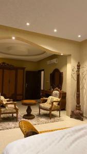 una camera con letto, sedie e TV di شقق قمم الصفوة للوحدات السكنية a Rafha