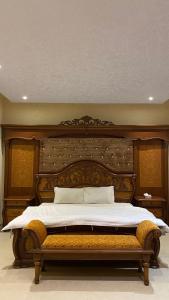 a bedroom with a large bed with a wooden headboard at شقق قمم الصفوة للوحدات السكنية in Rafha