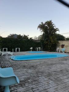 a swimming pool with chairs and a blue surfboard at Loft no Alto in Teresópolis